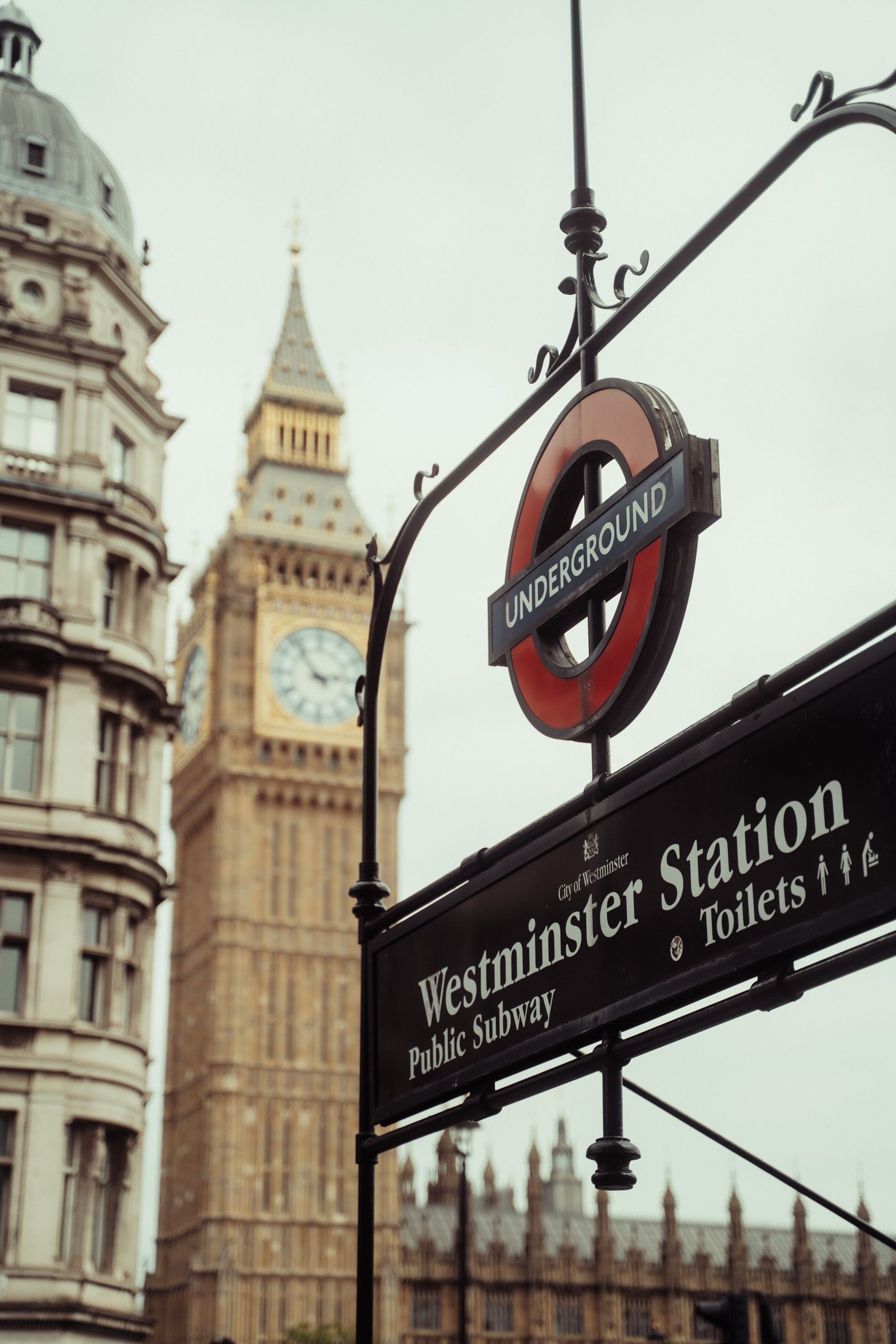 Iconic view of Westminster Station sign with Big Ben towering in the background in London, UK.